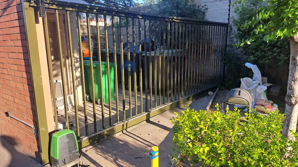 Instalación final de portón en acceso residencial o comercial, con ajustes y aseguramiento de funcionalidad