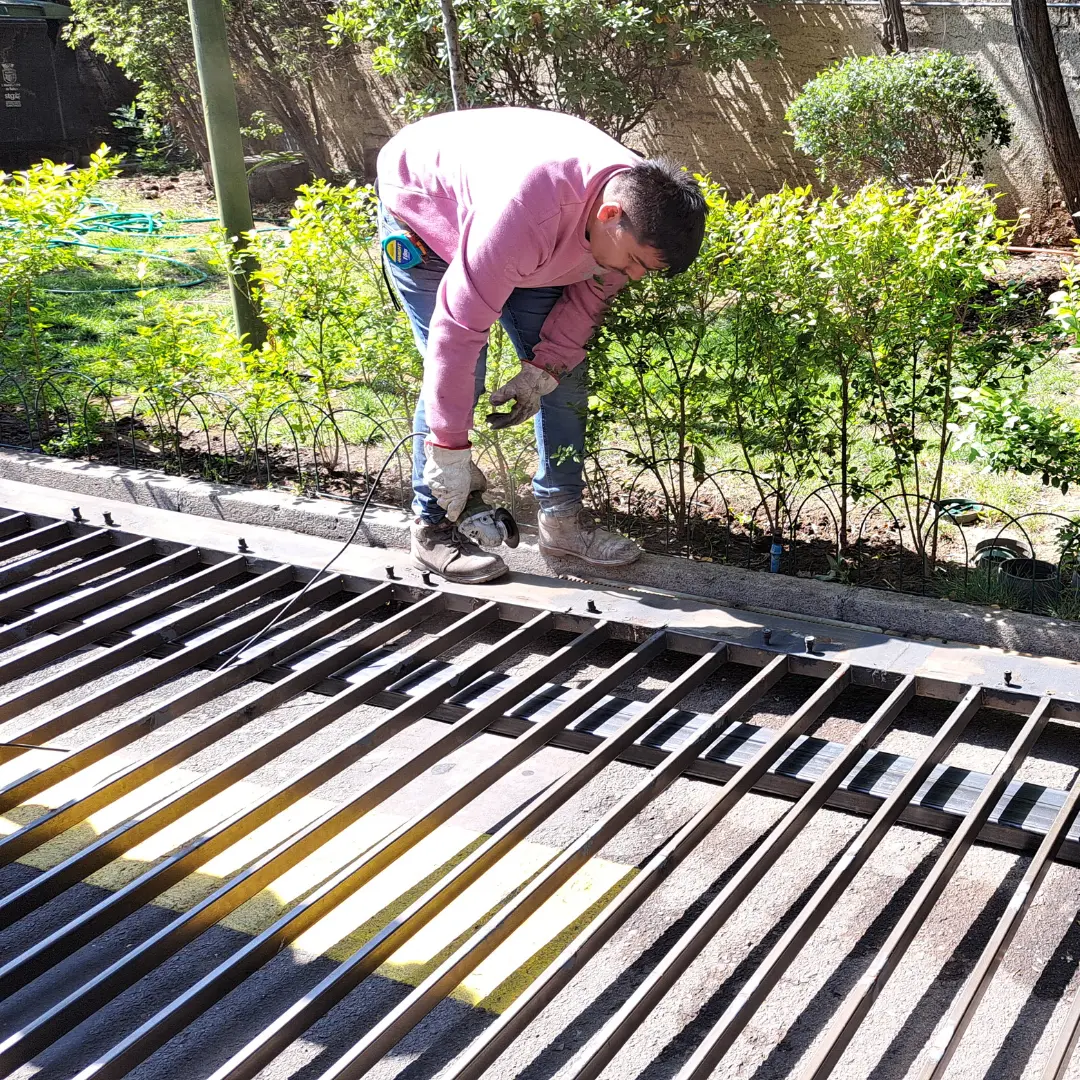 Soldador industrial cortando metal con equipo de protección personal